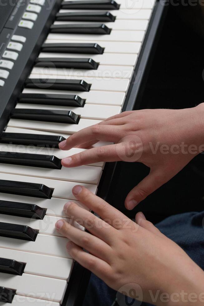 Piano music lessons. two hands playing chords and scales exercizes. Synthesizer keyboard close-up. photo