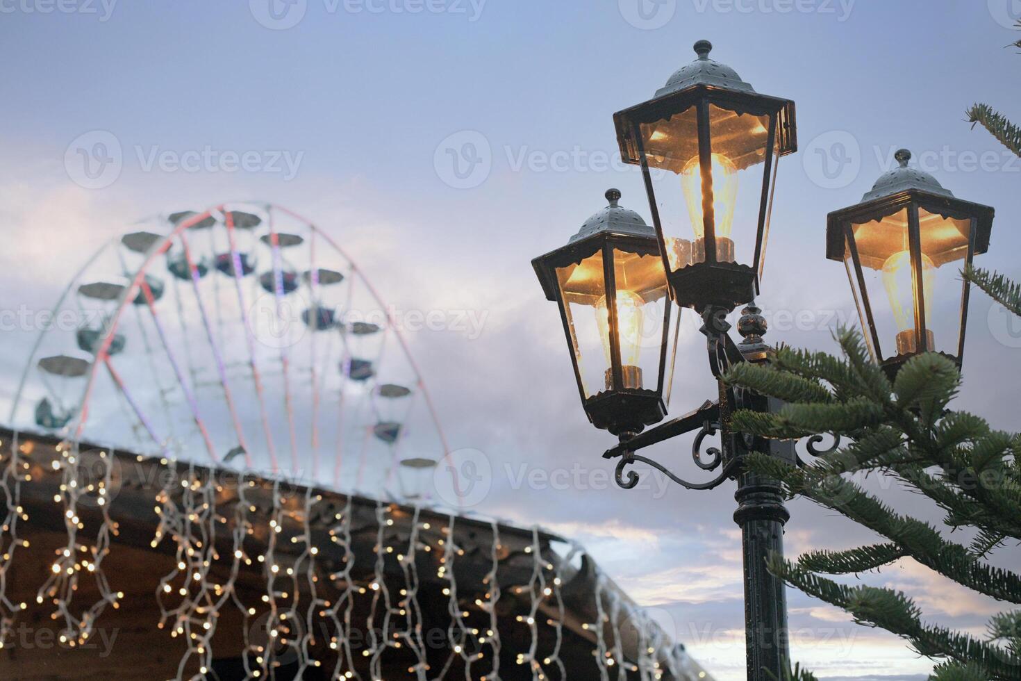 Old lantern, Ferris wheel and Christmas garlands. Beautiful view of the New Year's fair photo