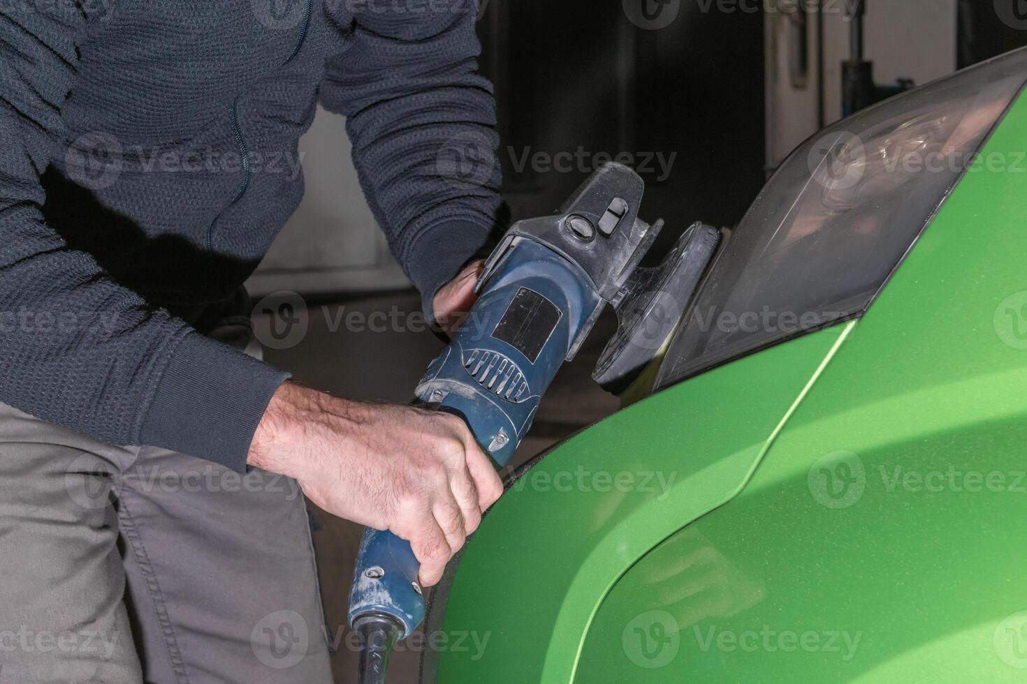 Polishing car headlights. Car service worker with electrical polisher polishing car photo