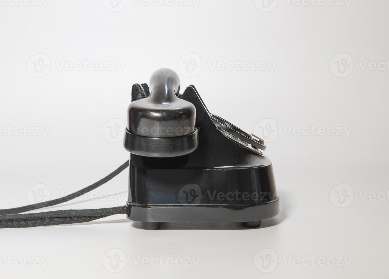 old rotary black telephone with traces of time. left side view. on white background photo
