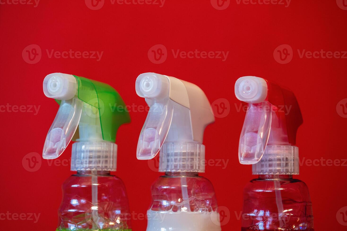 containers of cleaning agent on the red background. close-up photo
