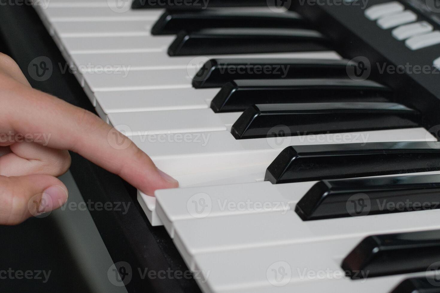 One finger piano keys playing. Music learning lessons. Synthesizer keyboard close-up photo