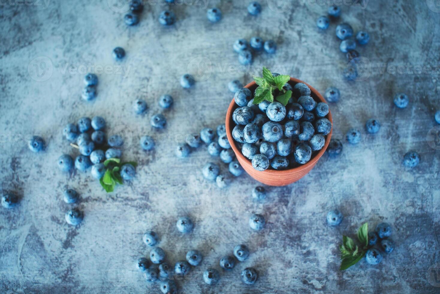 Fresh blueberries in a bowl on a rustic background, top view. Organic superfood and healthy berry. photo