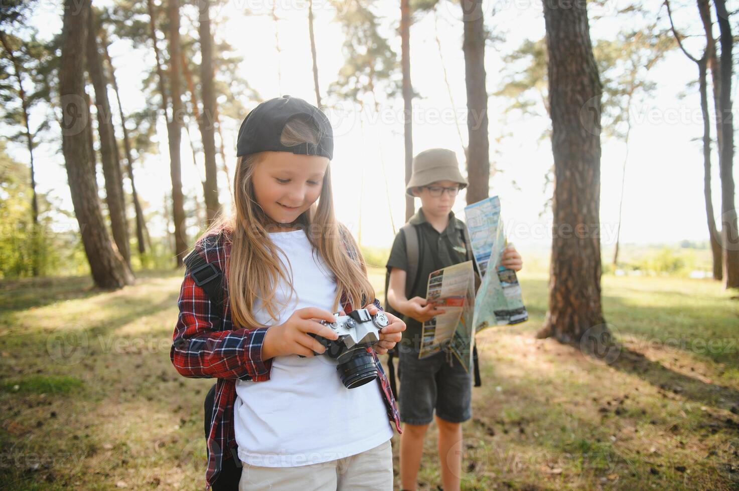 boy and girl go hiking with backpacks on forest road bright sunny day photo