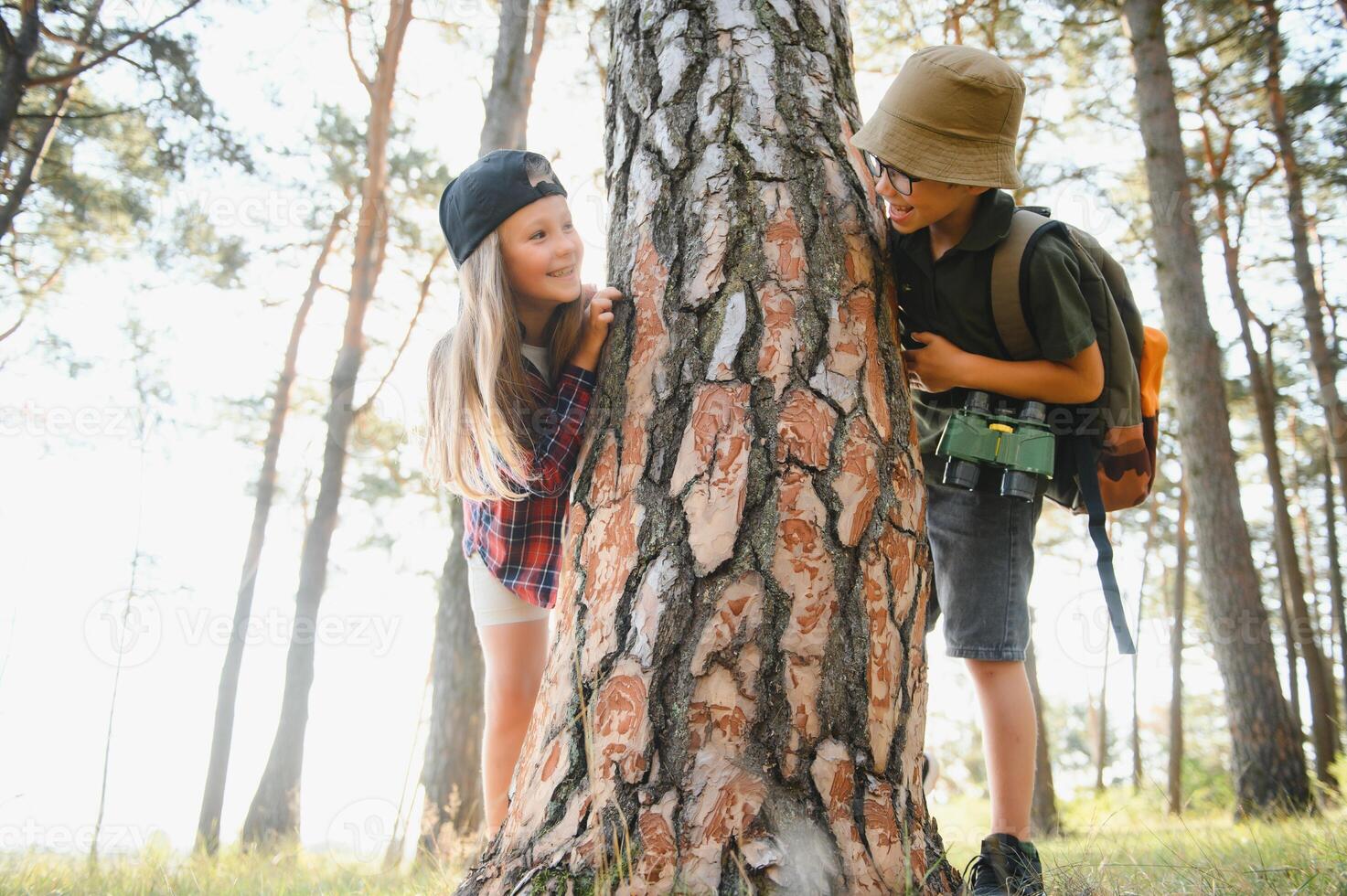 boy and girl go hiking with backpacks on forest road bright sunny day photo
