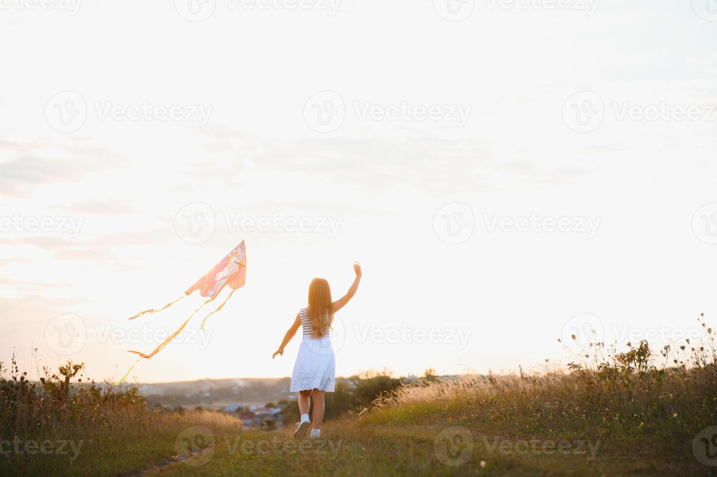 one happy little girl running on field with kite. photo