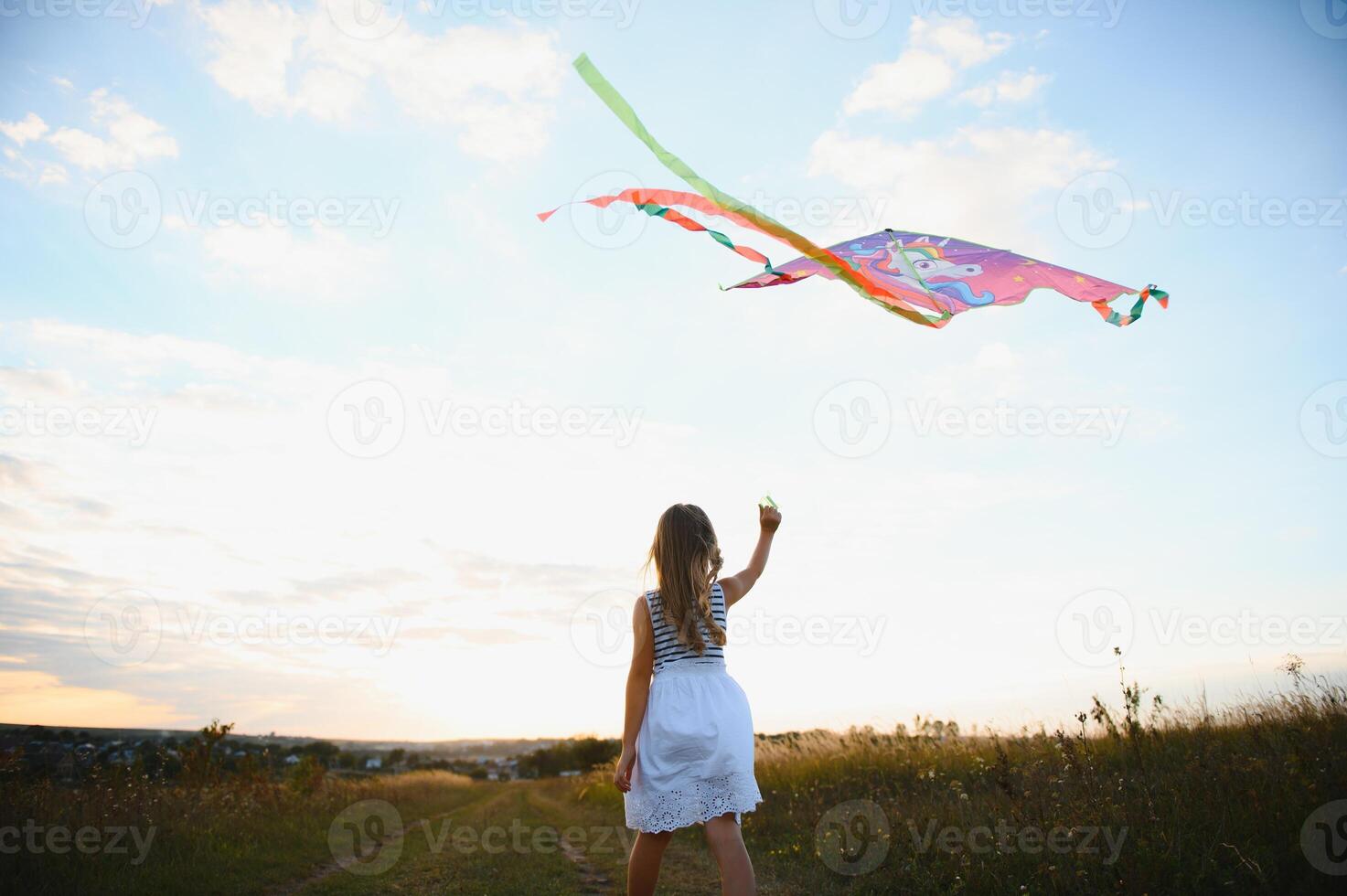 one happy little girl running on field with kite. photo