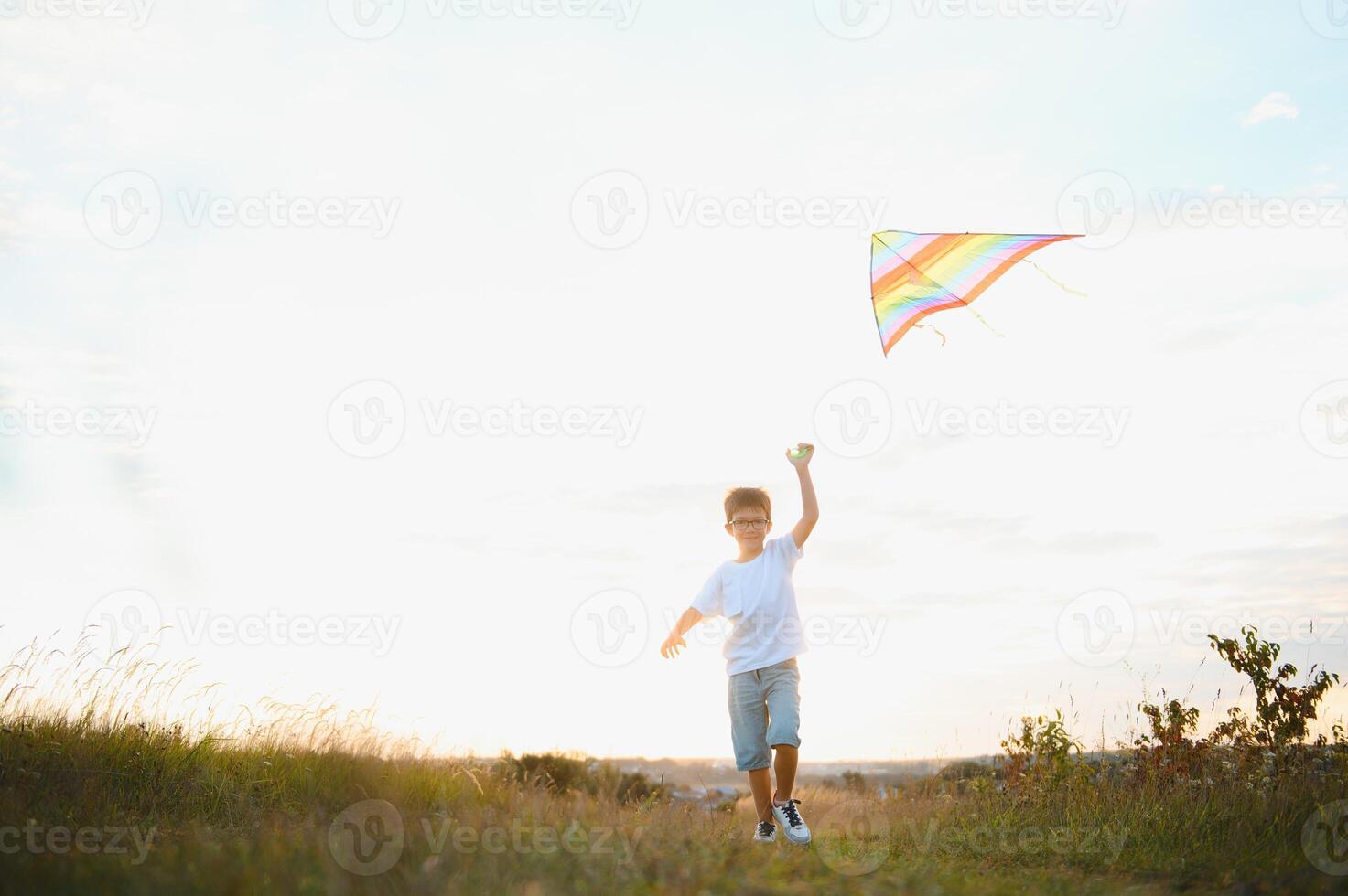 Children launch a kite in the field at sunset. photo