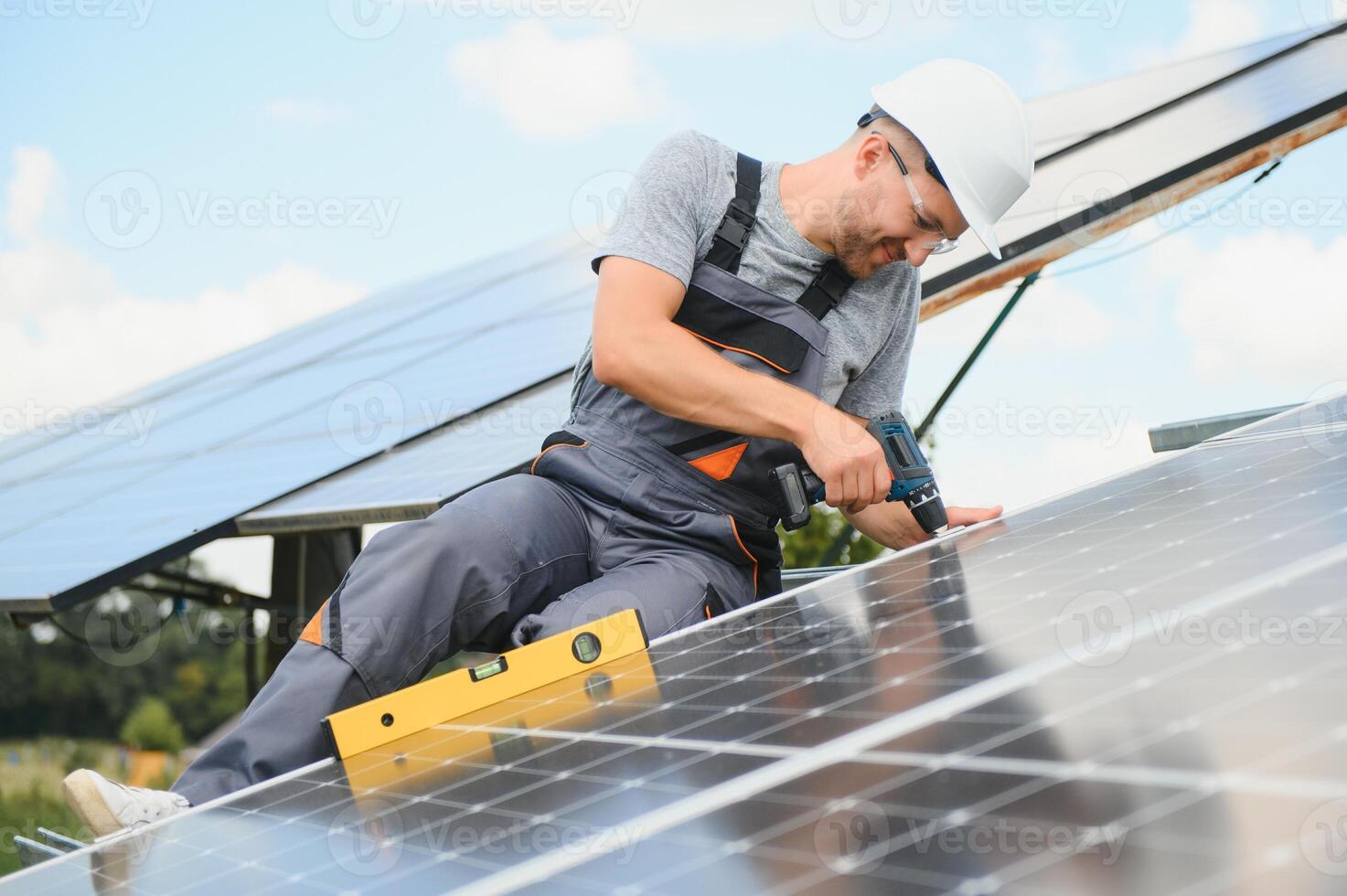 Male engineer in protective helmet installing solar photovoltaic panel system. Alternative energy ecological concept. photo