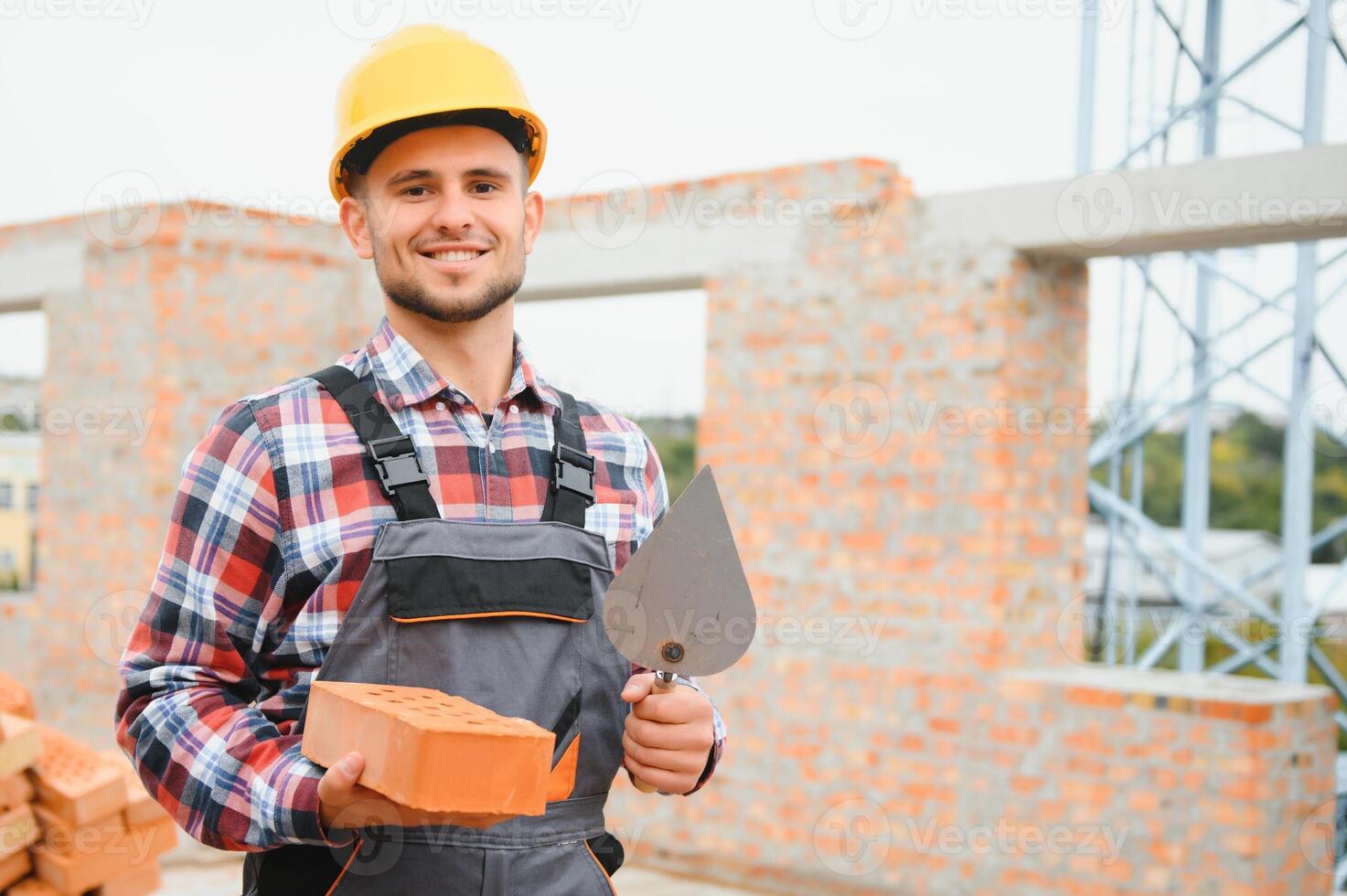Installing brick wall. Construction worker in uniform and safety equipment have job on building photo