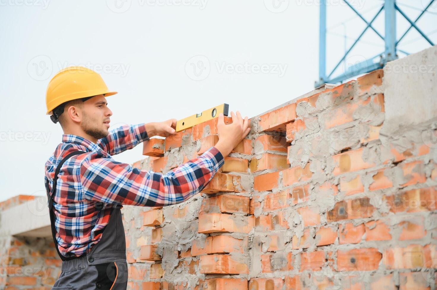 Construction worker in uniform and safety equipment have job on building photo