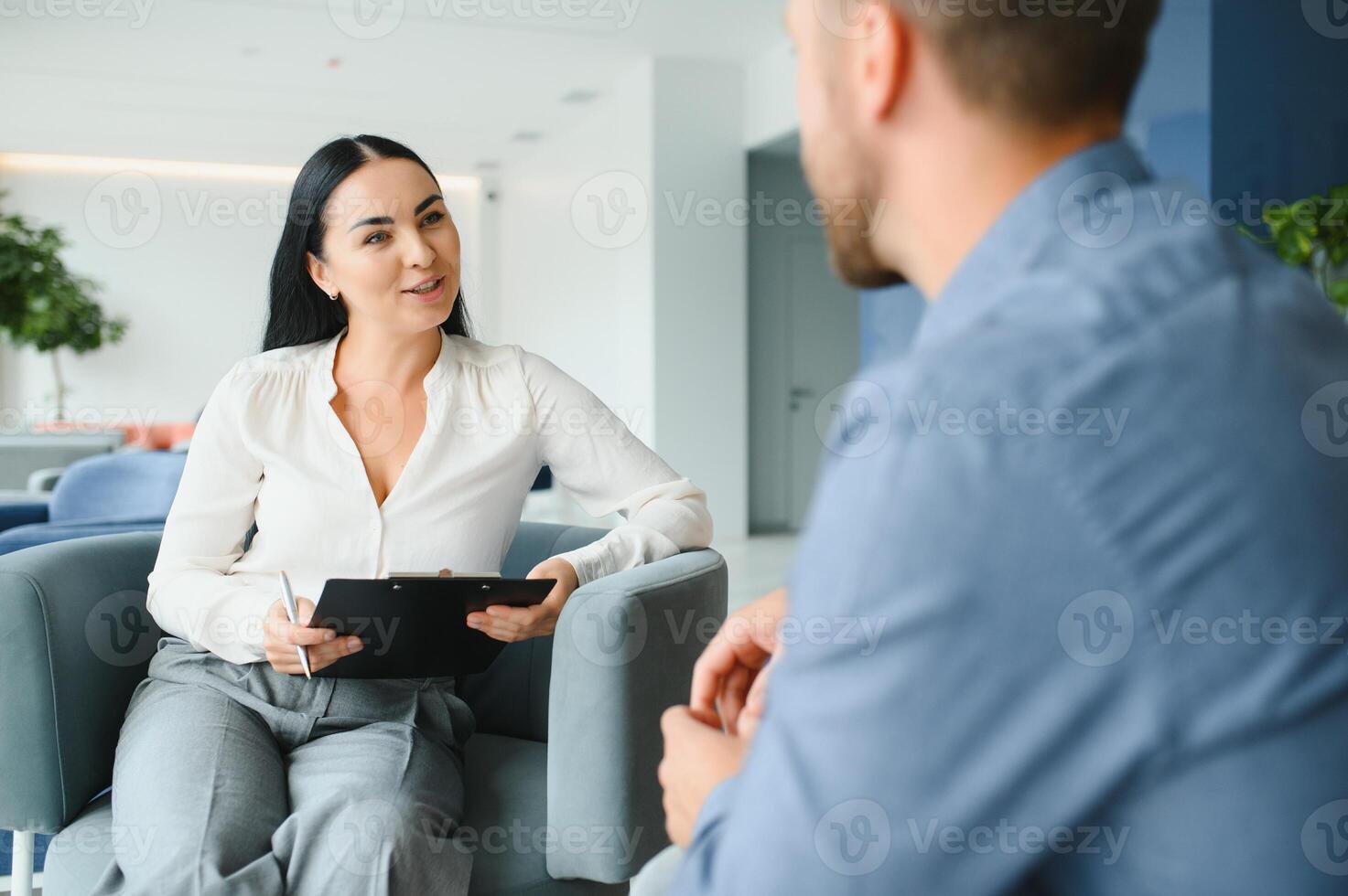Business concept. Young dark-haired woman sitting in front of mature cheerful office manager on job interview, having relaxing talk about her experience and study degree. photo