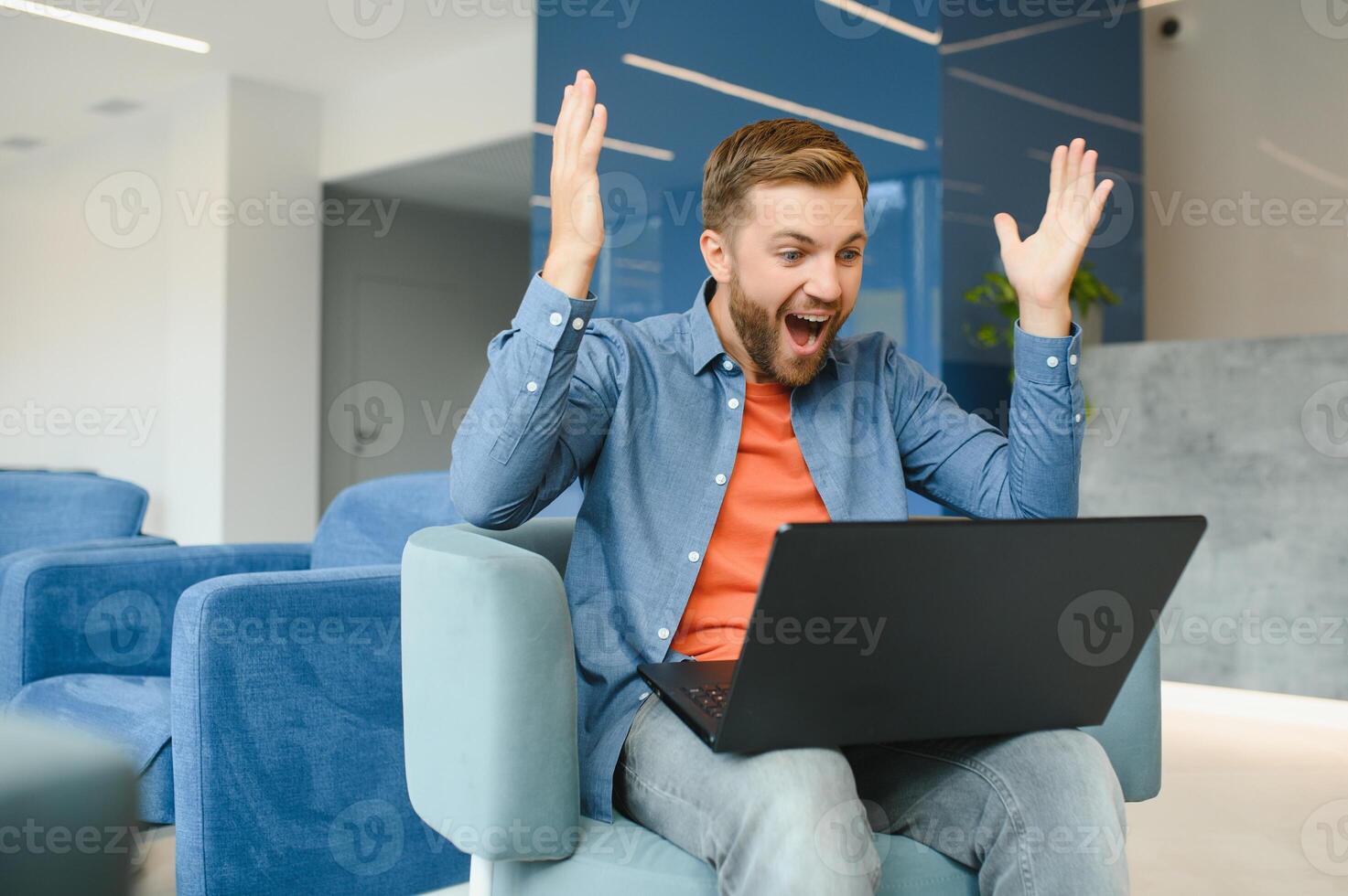 Photo of young excited man happy positive smile celebrate win victory success fists hands sit sofa home remote work.