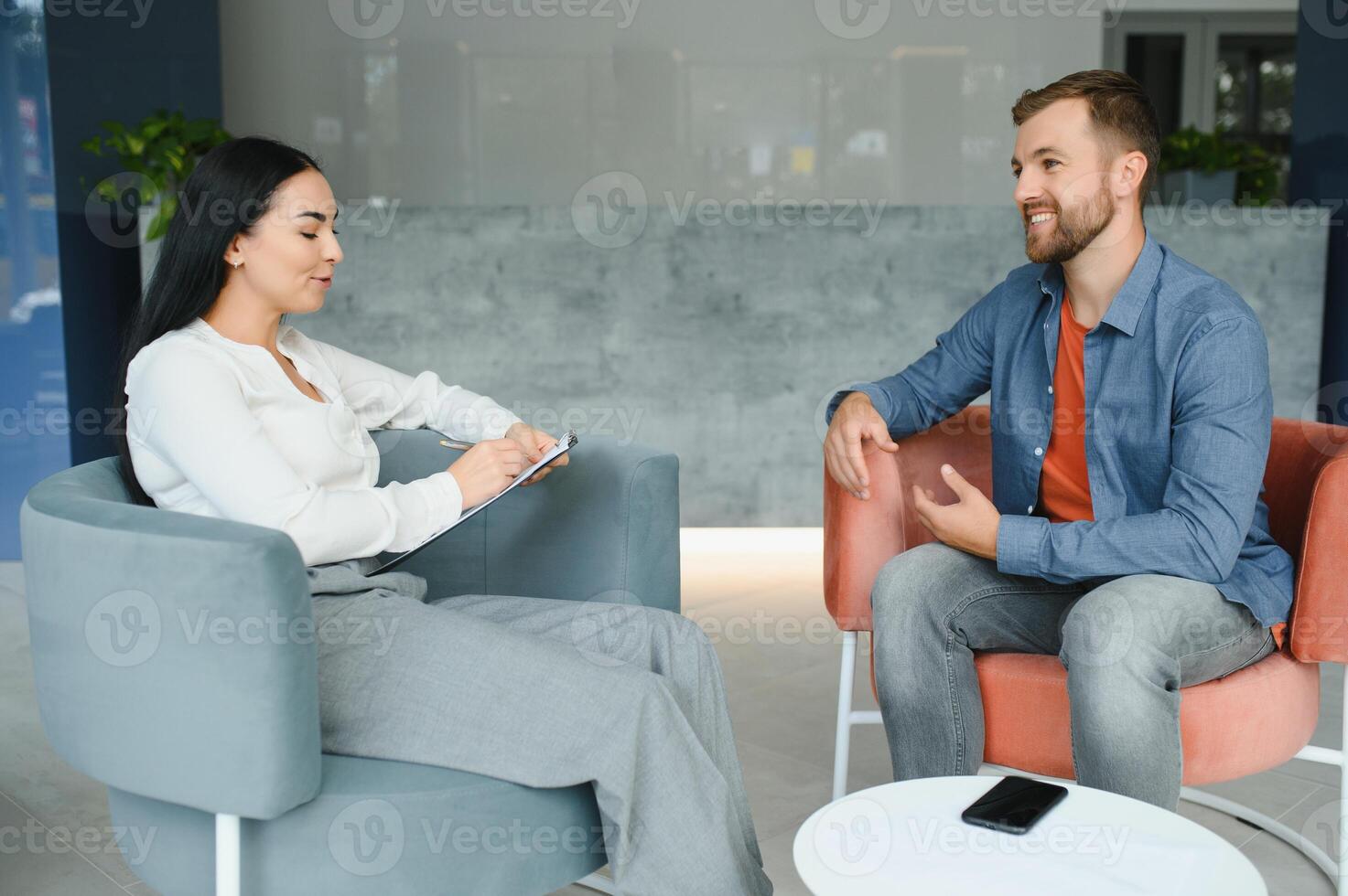 Business concept. Young dark-haired woman sitting in front of mature cheerful office manager on job interview, having relaxing talk about her experience and study degree. photo