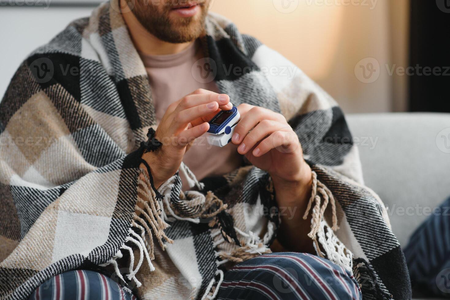 Close up of oximeter on hand of ill person resting while measuring oxygen saturation and pulse pressure to check virus symptoms. Sick adult using device for healthcare treatment. photo