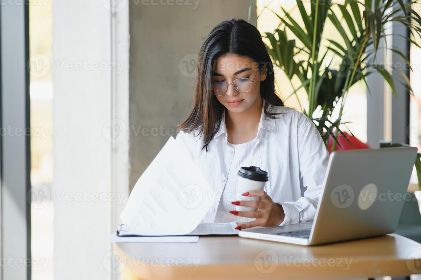 Beautiful Caucasian woman dreaming about something while sitting with portable net-book in modern cafe bar, young charming female freelancer thinking about new ideas during work on laptop computer photo