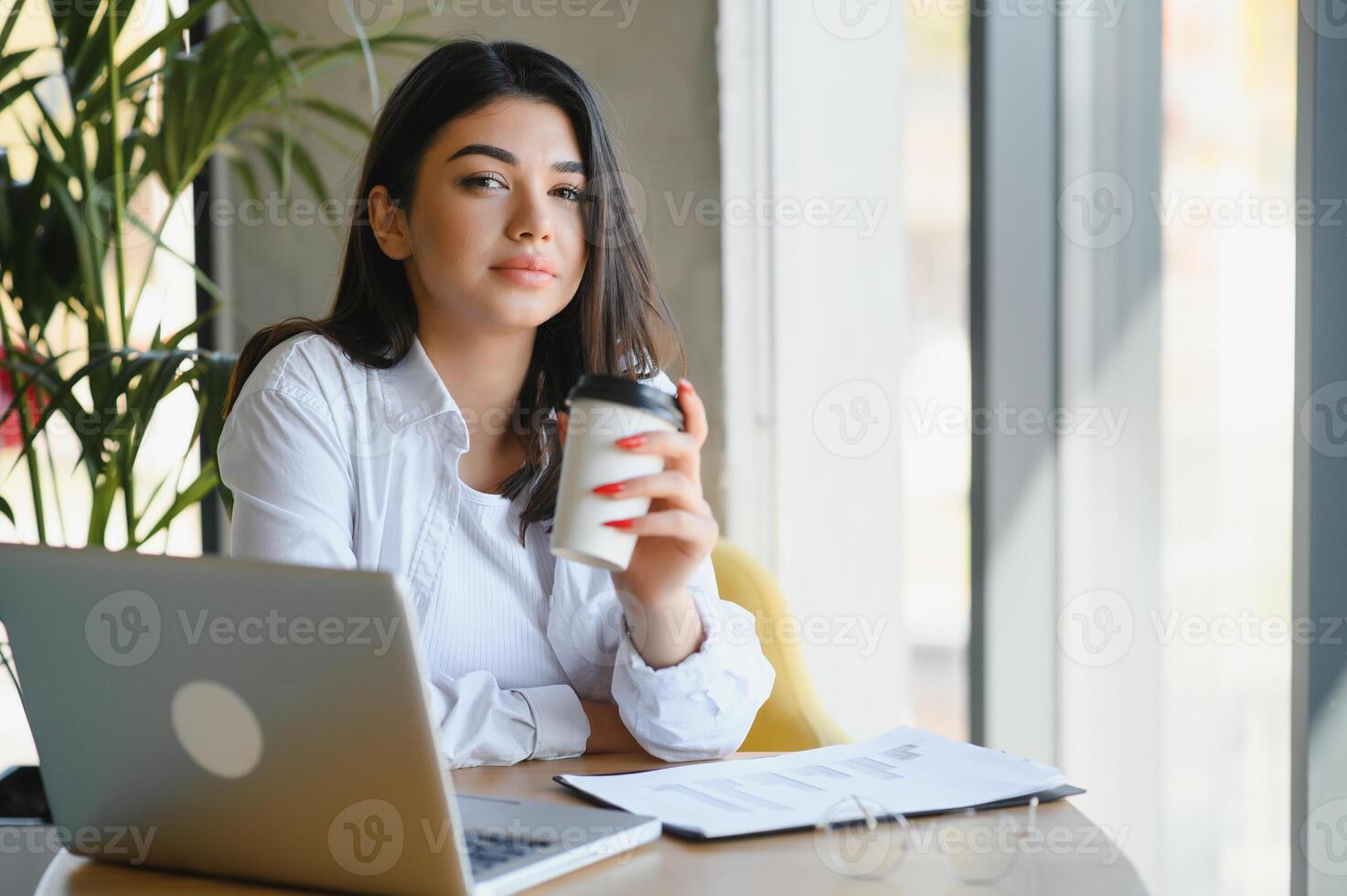 Beautiful Caucasian woman dreaming about something while sitting with portable net-book in modern cafe bar, young charming female freelancer thinking about new ideas during work on laptop computer photo