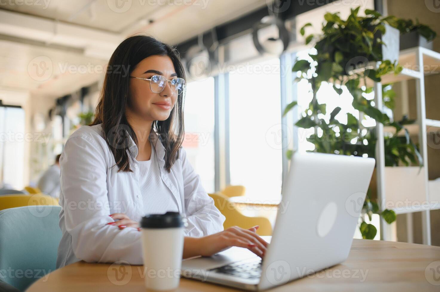 Beautiful Caucasian woman dreaming about something while sitting with portable net-book in modern cafe bar, young charming female freelancer thinking about new ideas during work on laptop computer photo