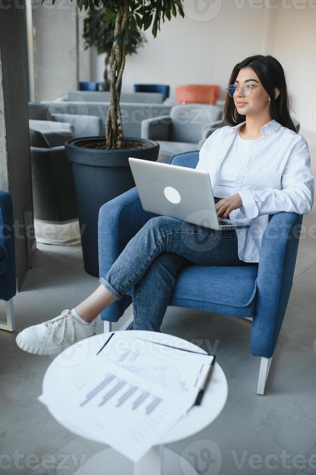 Beautiful Caucasian woman dreaming about something while sitting with portable net-book in modern cafe bar, young charming female freelancer thinking about new ideas during work on laptop computer photo