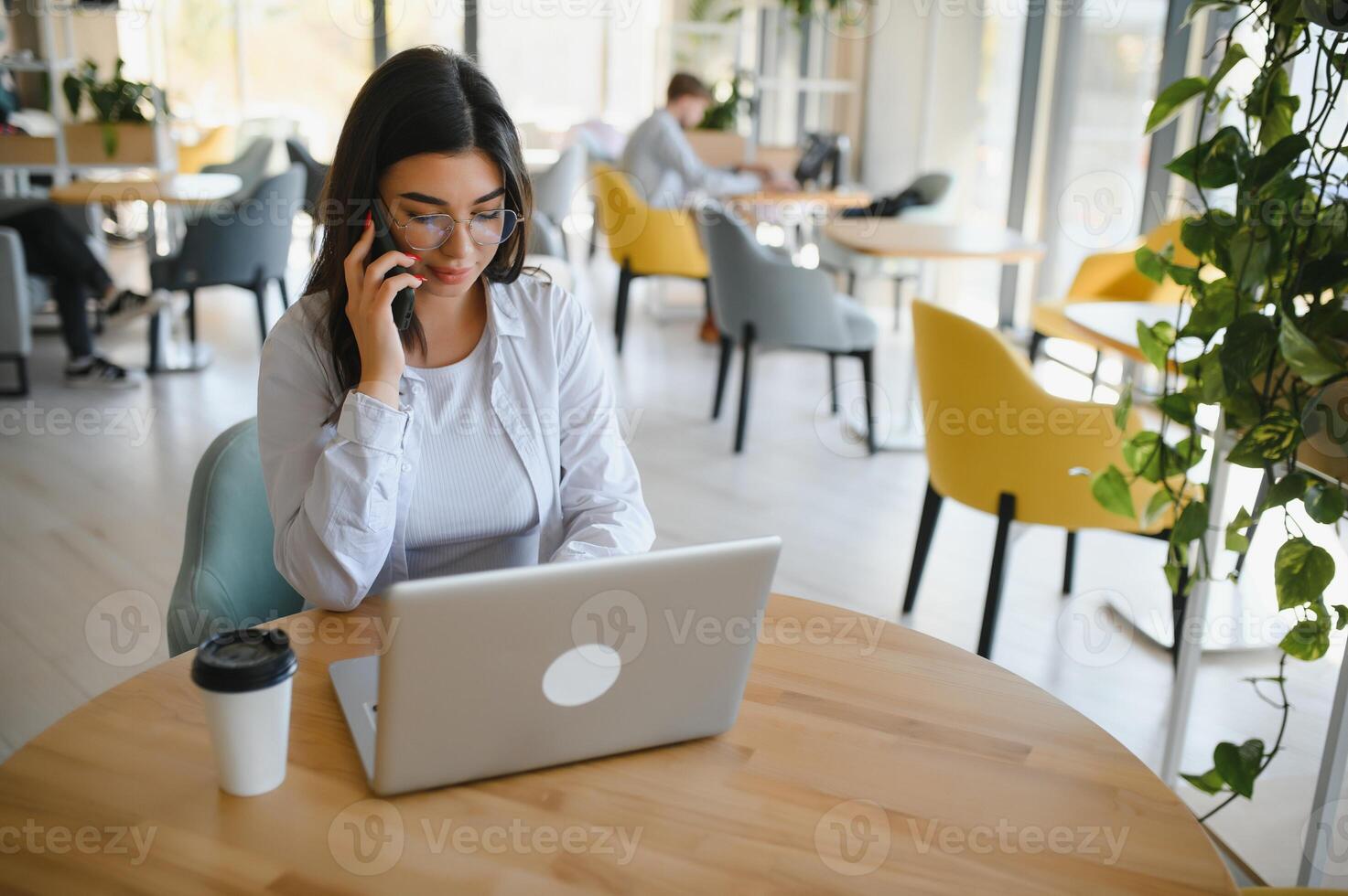 Freelance, business and e-commerce concept. Creative enthusiastic female journalist writing new article, typing on laptop, smiling, write-down project ideas, sit cafe, drink coffee working remote photo