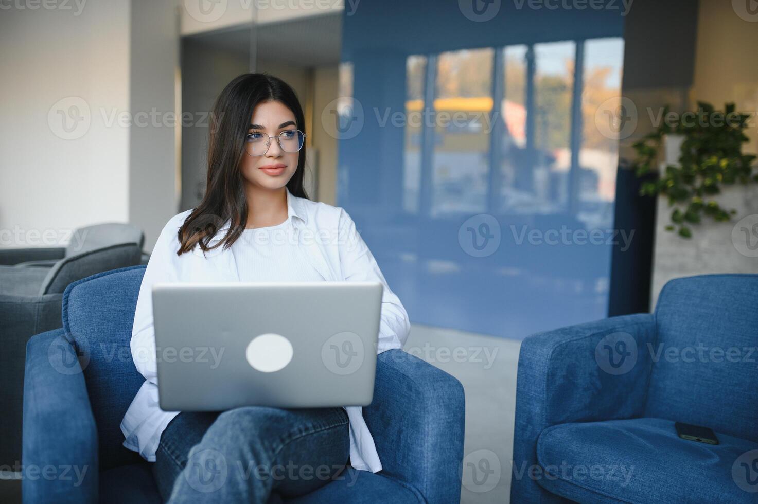 Beautiful Caucasian woman dreaming about something while sitting with portable net-book in modern cafe bar, young charming female freelancer thinking about new ideas during work on laptop computer photo