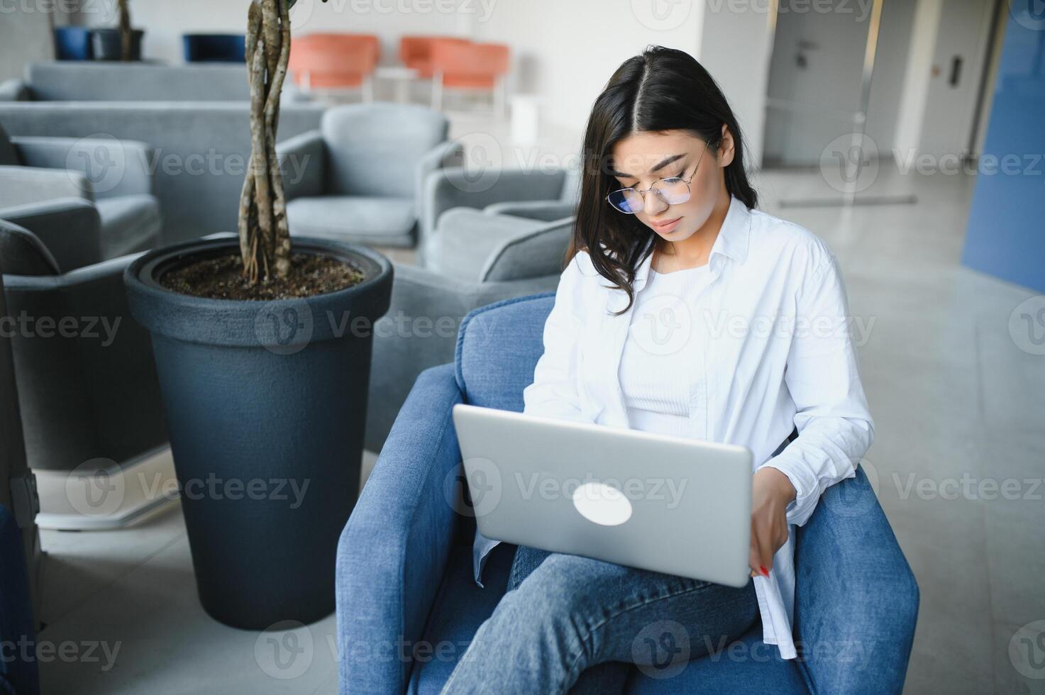 Beautiful Caucasian woman dreaming about something while sitting with portable net-book in modern cafe bar, young charming female freelancer thinking about new ideas during work on laptop computer photo