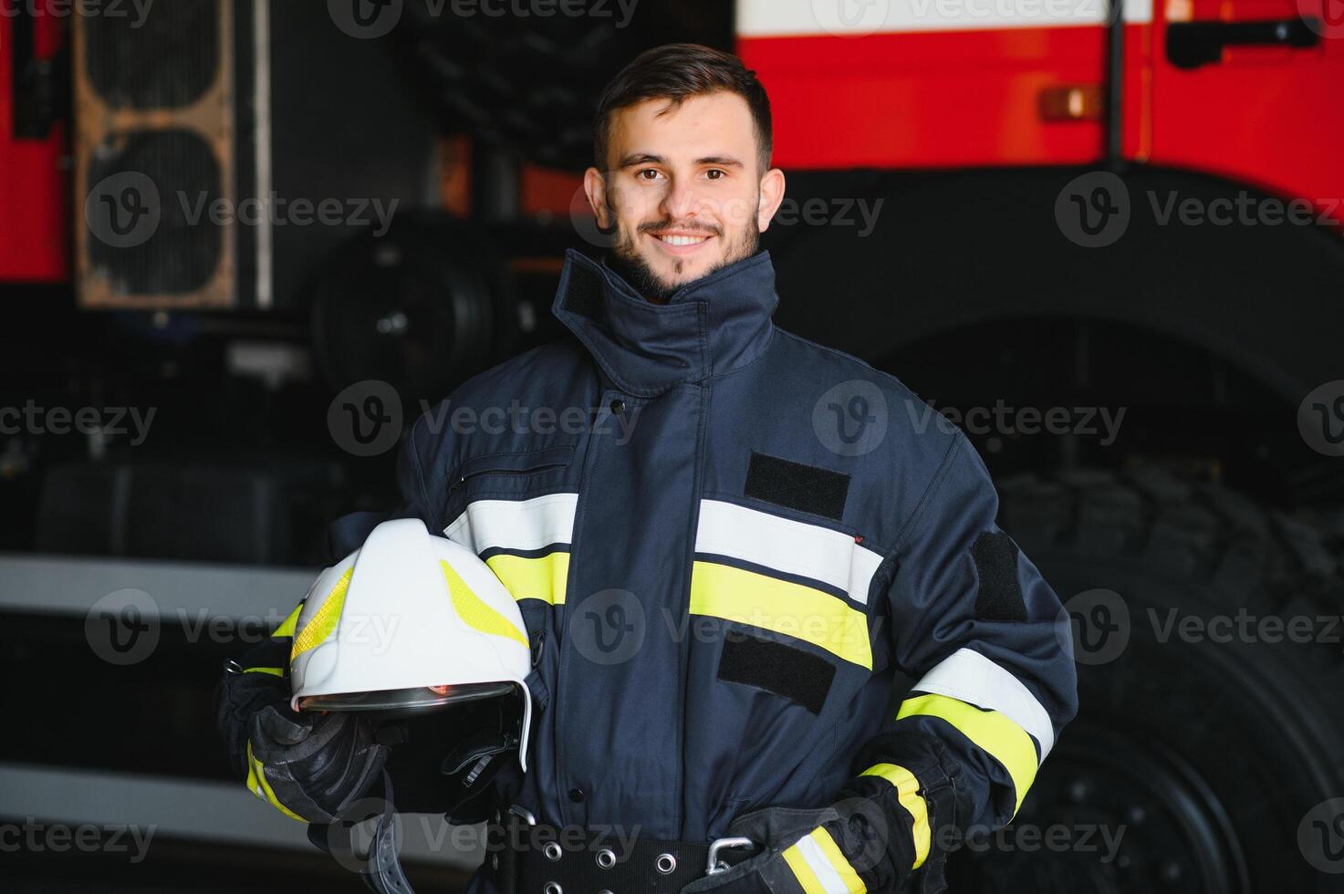 Portrait of a firefighter standing in front of a fire engine photo