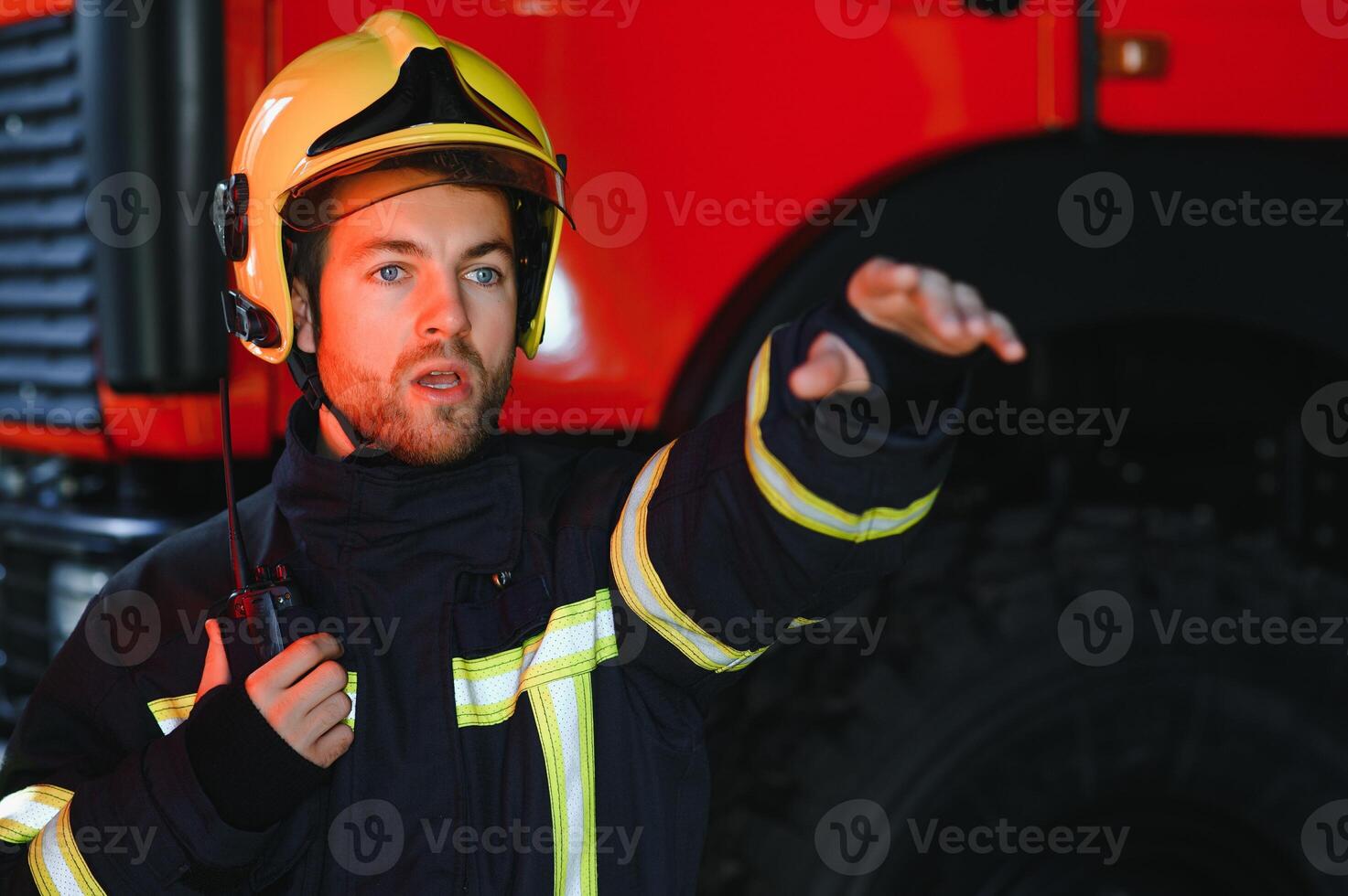 Fireman firefighter in action standing near a firetruck. Emergency safety. Protection, rescue from danger. photo