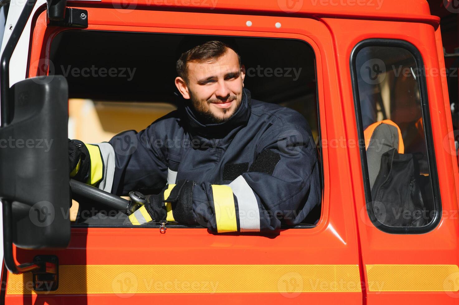 Firefighter at the wheel of an emergency vehicle drives to the scene of action and extinguishes fire. photo