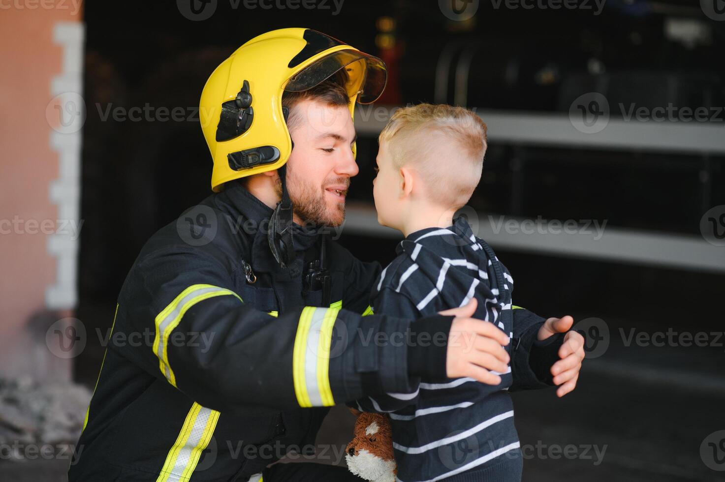 Firefighter holding child boy to save him in fire and smoke,Firemen rescue the boys from fire photo