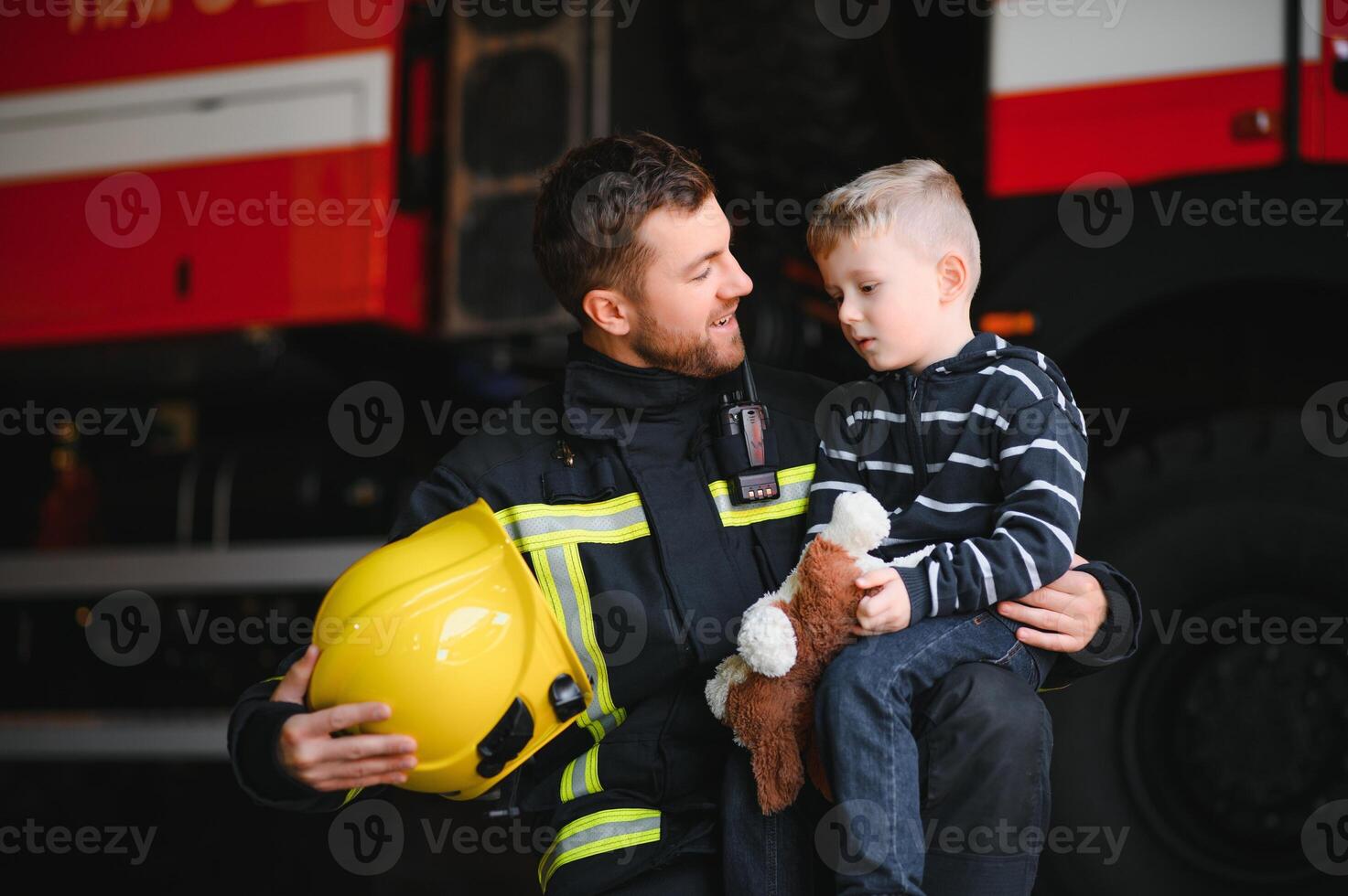 Firefighter holding child boy to save him in fire and smoke,Firemen rescue the boys from fire photo