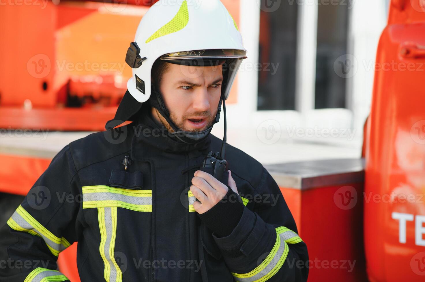 Firefighter portrait on duty. Photo fireman with gas mask and helmet near fire engine.