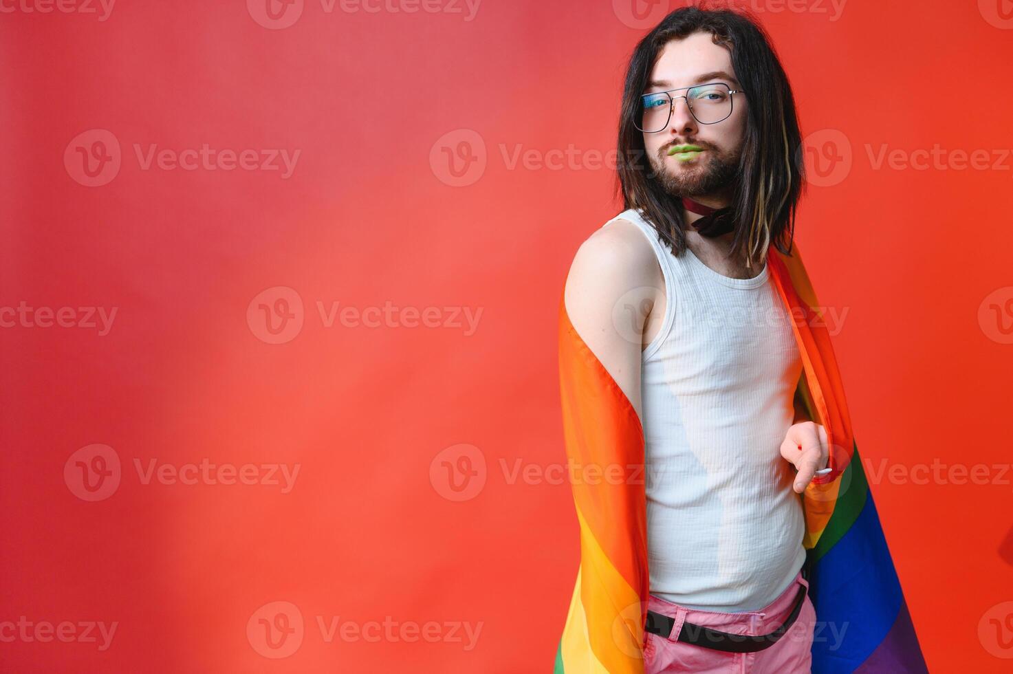 Young, handsome gay man on a colored background in the studio. LGBT concept. photo