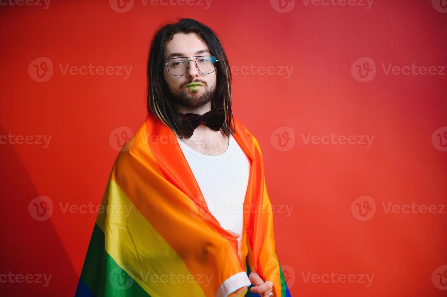 Gay man hold rainbow striped flag isolated on colored background studio portrait. People lifestyle fashion lgbtq concept photo