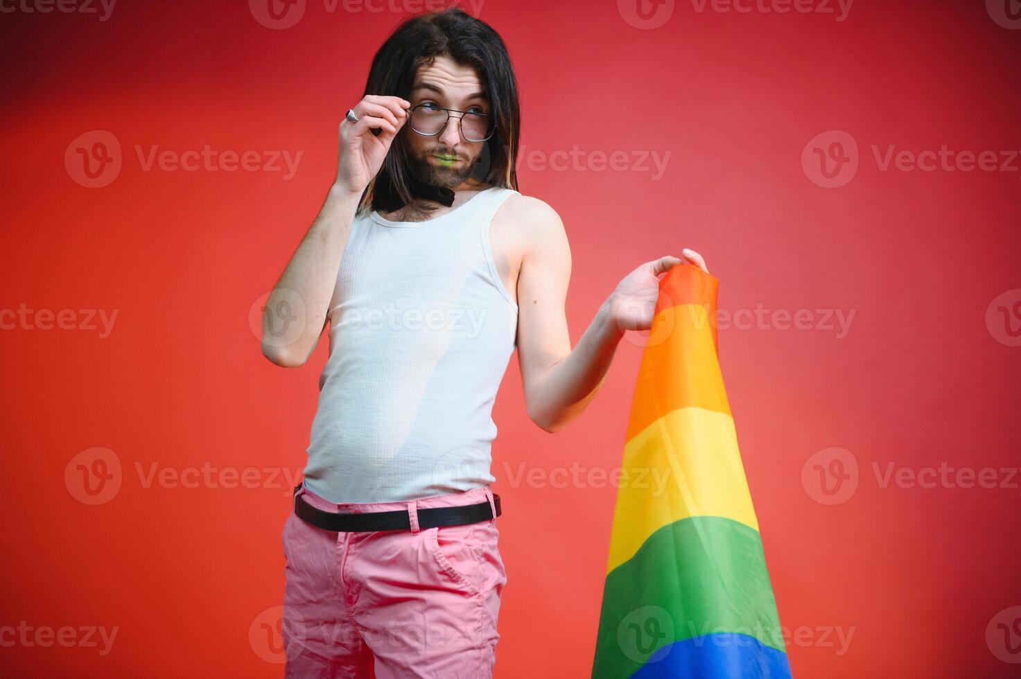 Young gay man is standing in the studio and posing for a camera. photo