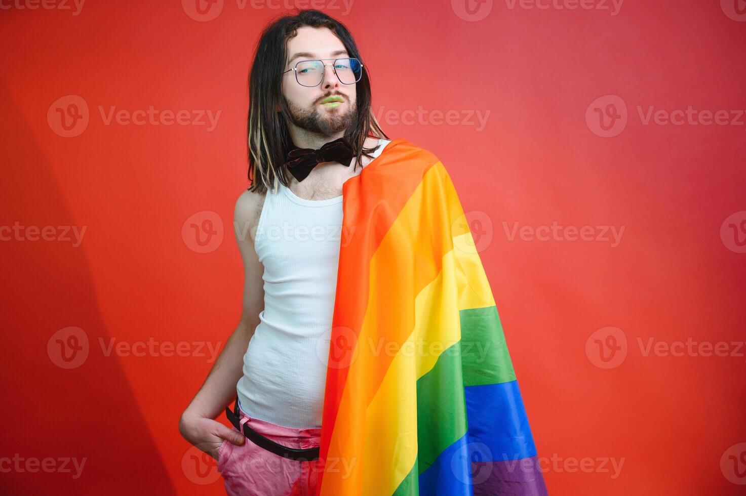Happy gay man having fun holding rainbow flag symbol of LGBTQ community photo
