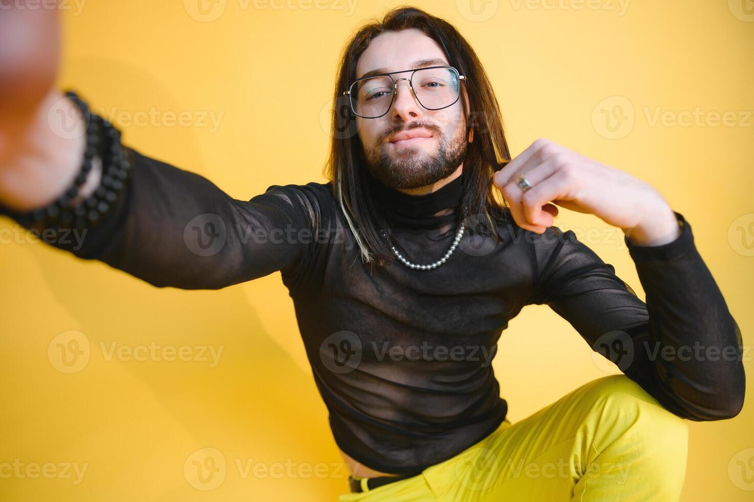 Young, handsome gay man on a colored background in the studio. LGBT concept. photo