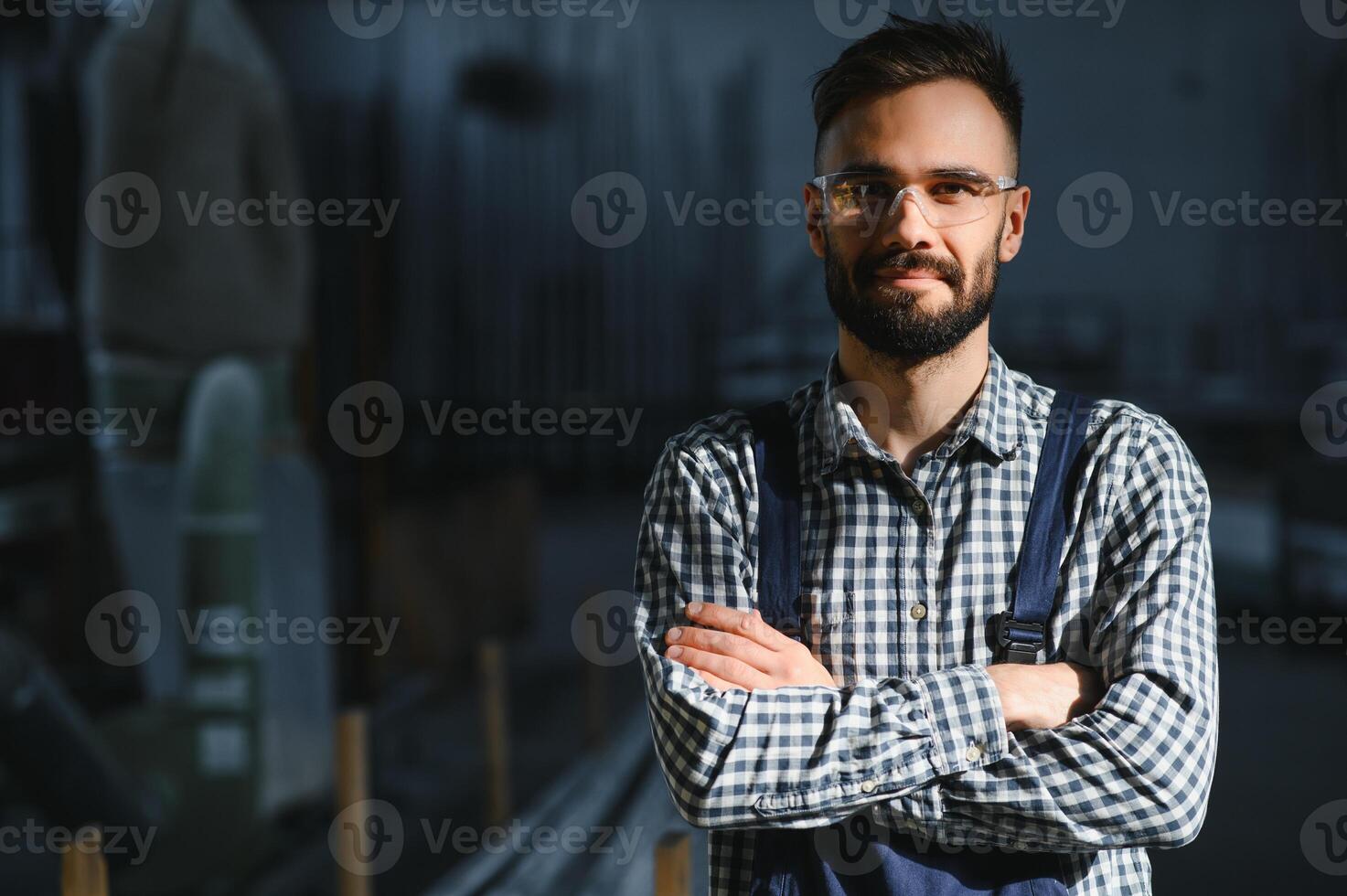 Portrait of industrial engineer. Factory worker with hard hat standing in factory. photo