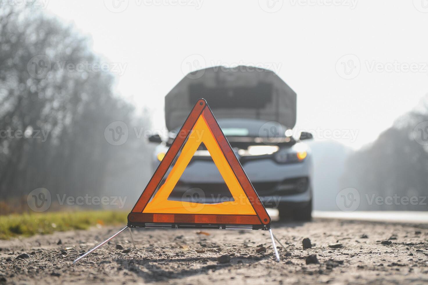 Red emergency stop sign and broken silver SUV car on the road. photo