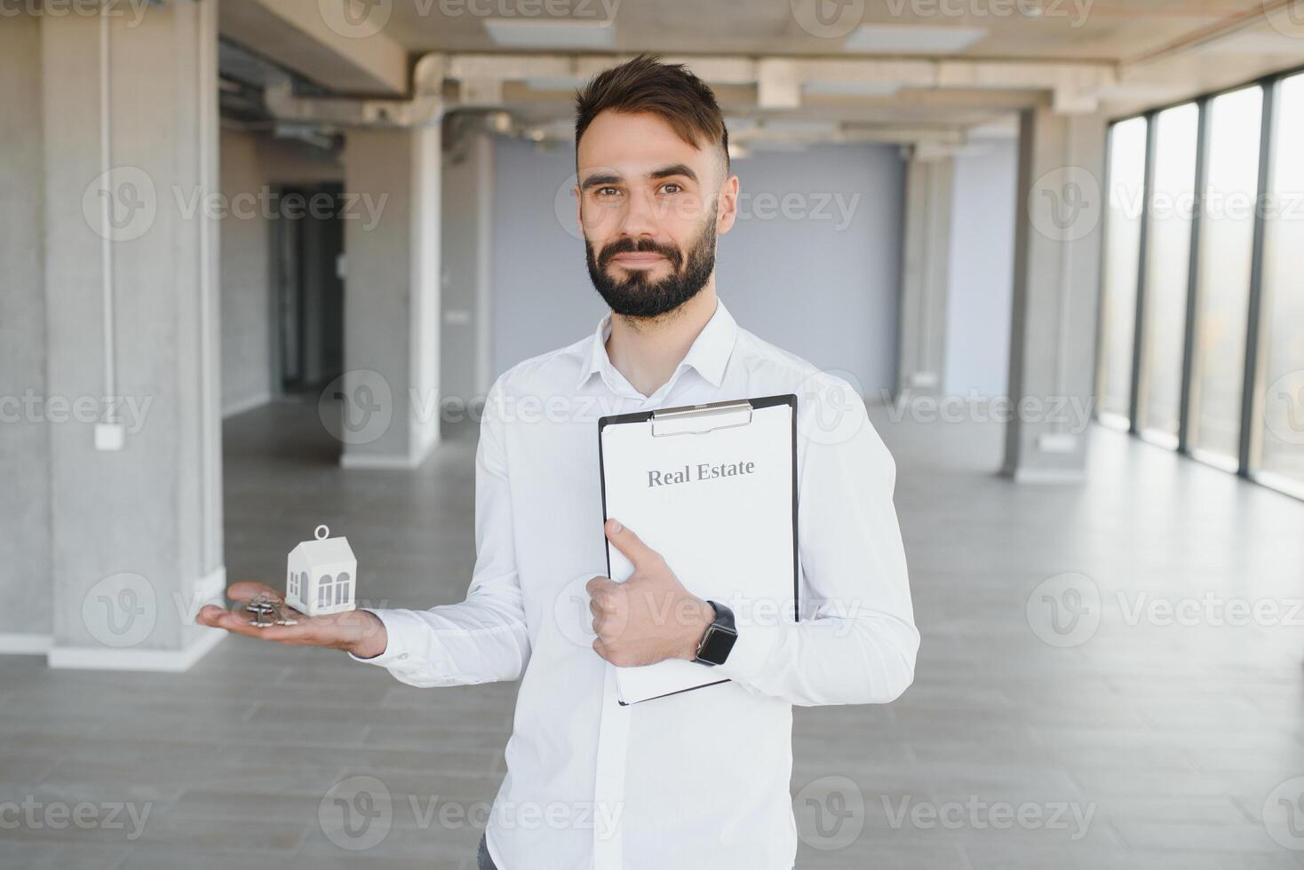 Male real estate agent with key in room. Banner for design photo