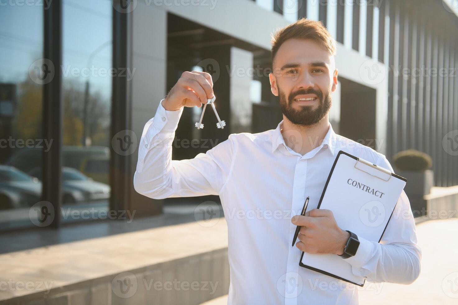 Male Realtor Standing Outside Residential Property Holding Keys photo