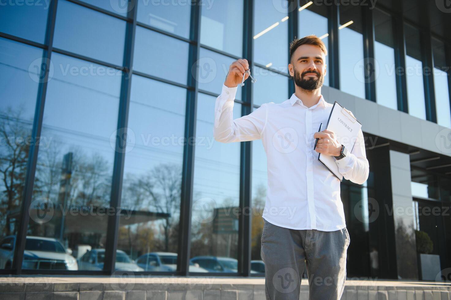 Businessman or real estate agent ready to discuss business and stands against new building photo