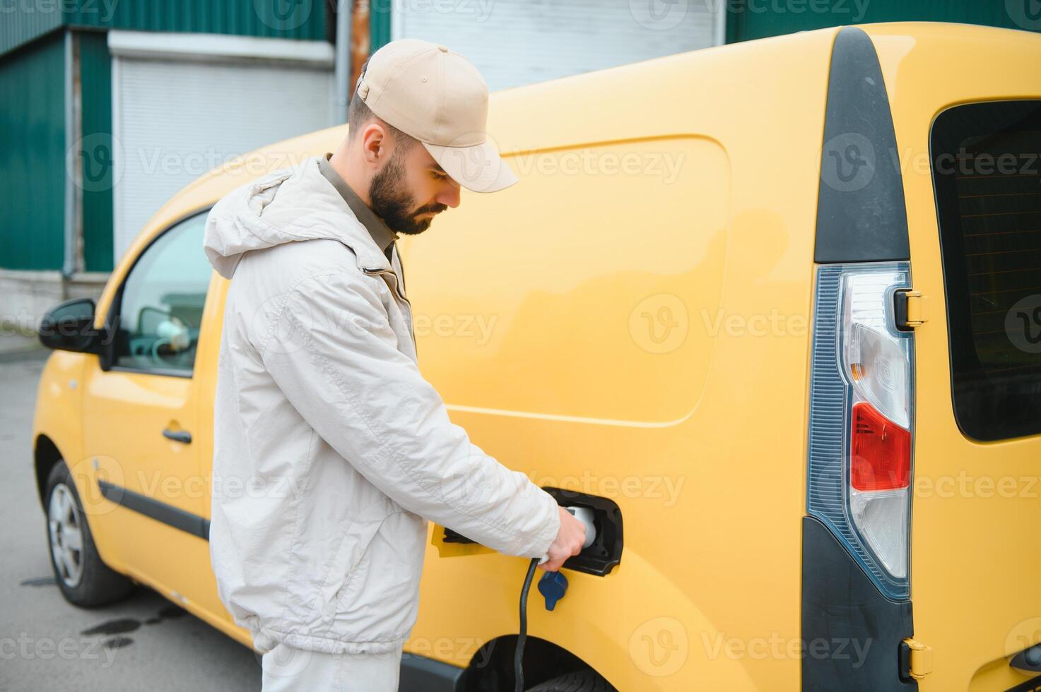 Man charging electric car by the work photo