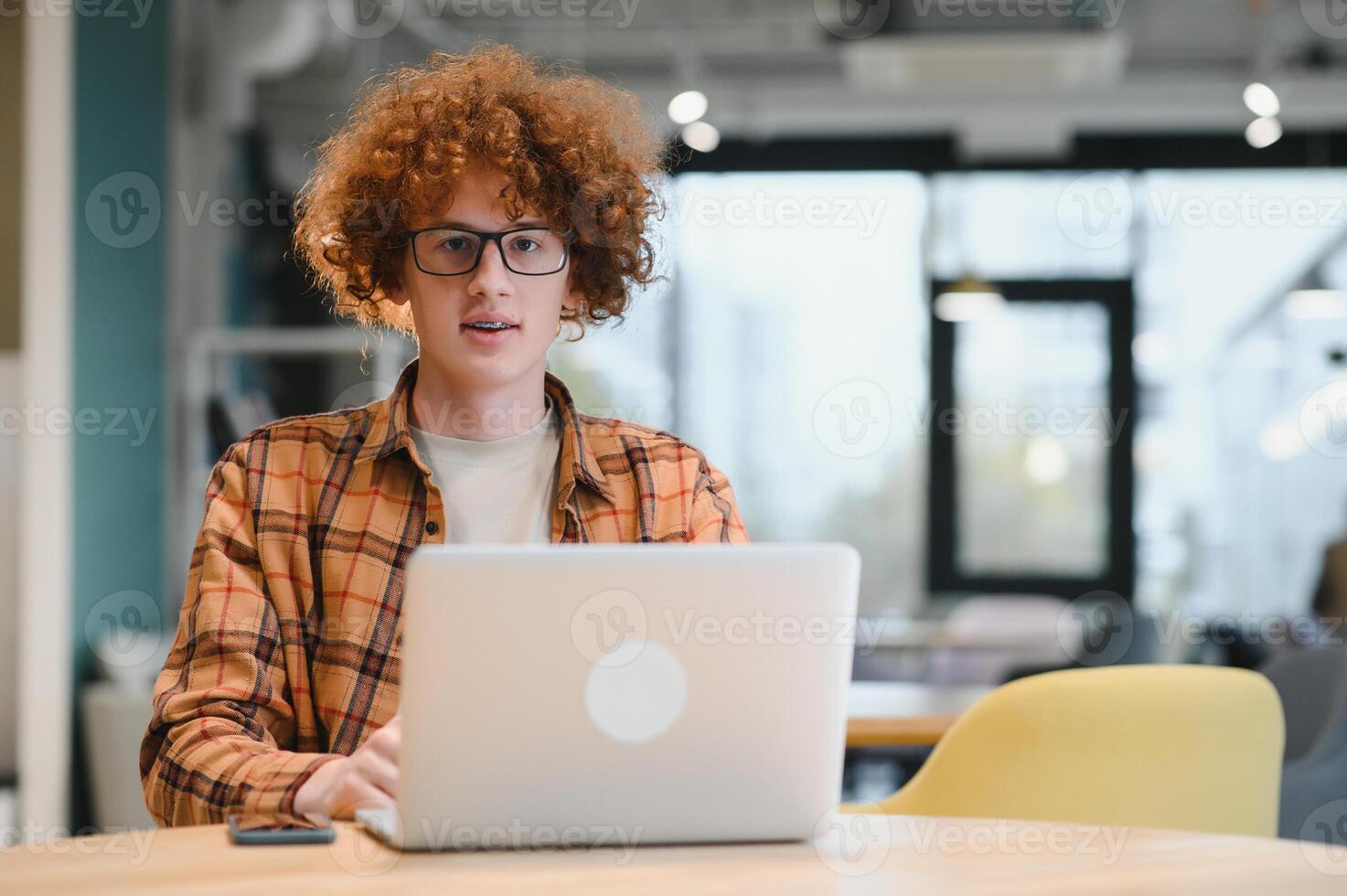male programmer wear spectacles for eyes protection while working on freelance via laptop computer,clever student watching tutorial on netbook. photo