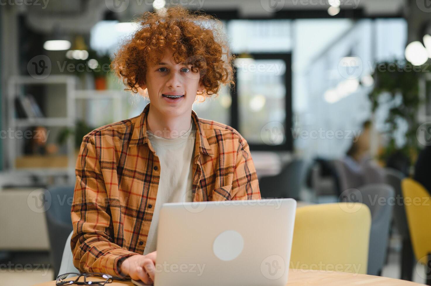 Cheerful male freelancer browsing funny content while networking in social media using netbook technology in street cafe, happy hipster guy enjoying free time for online blogging via laptop photo