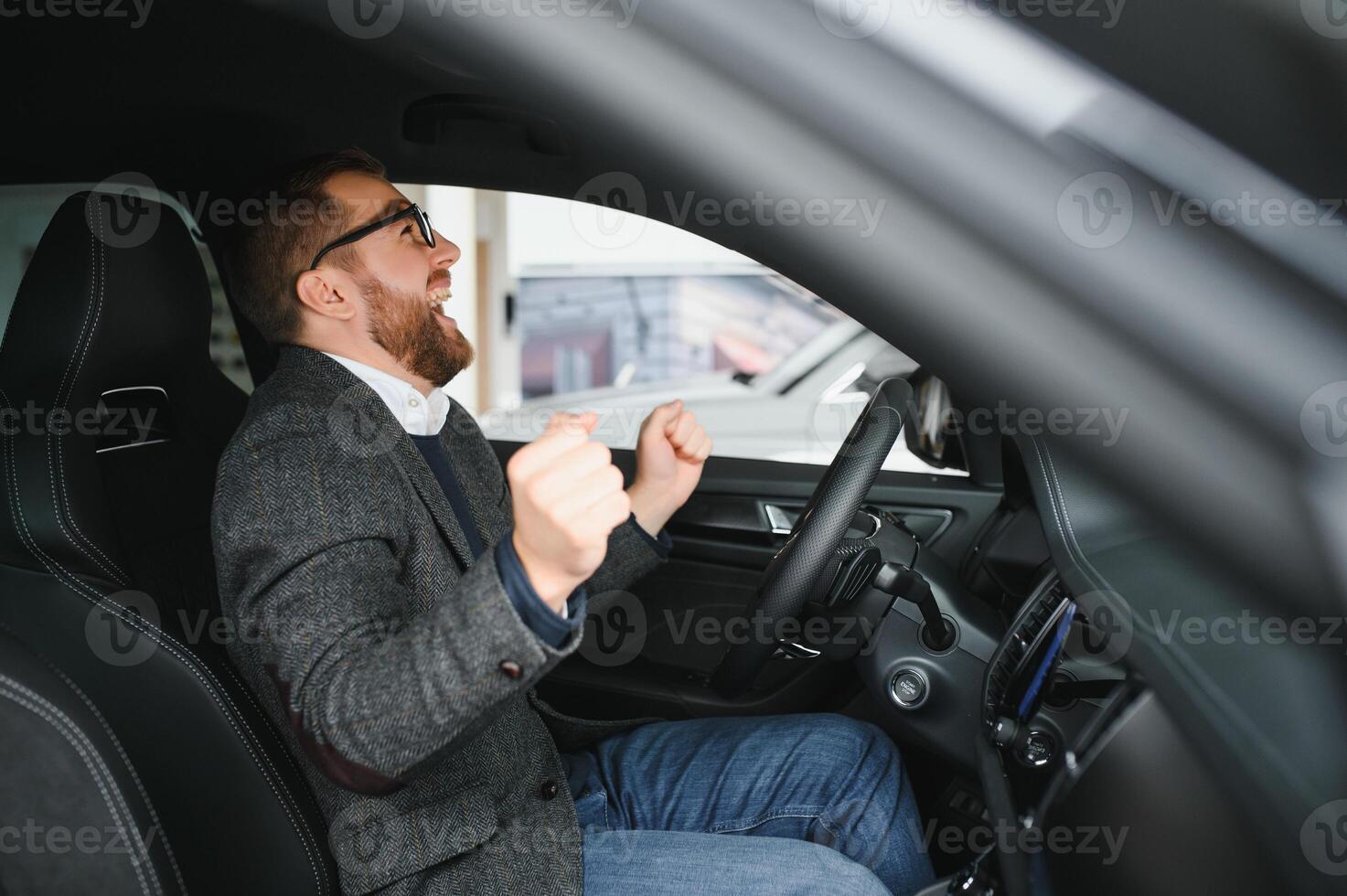 Handsome businessman driving car before buying photo