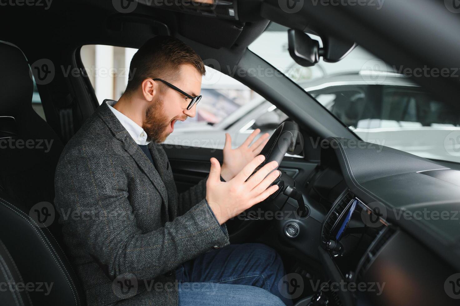 Visiting car dealership. Handsome bearded man is stroking his new car and smiling photo