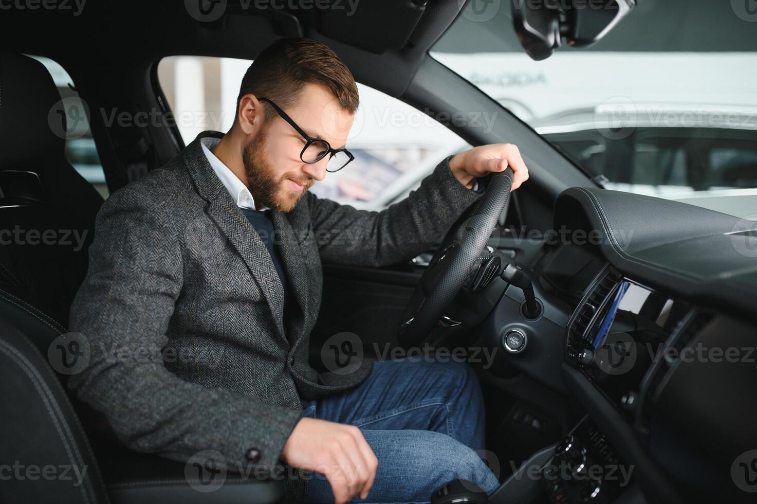 Visiting car dealership. Handsome bearded man is stroking his new car and smiling photo
