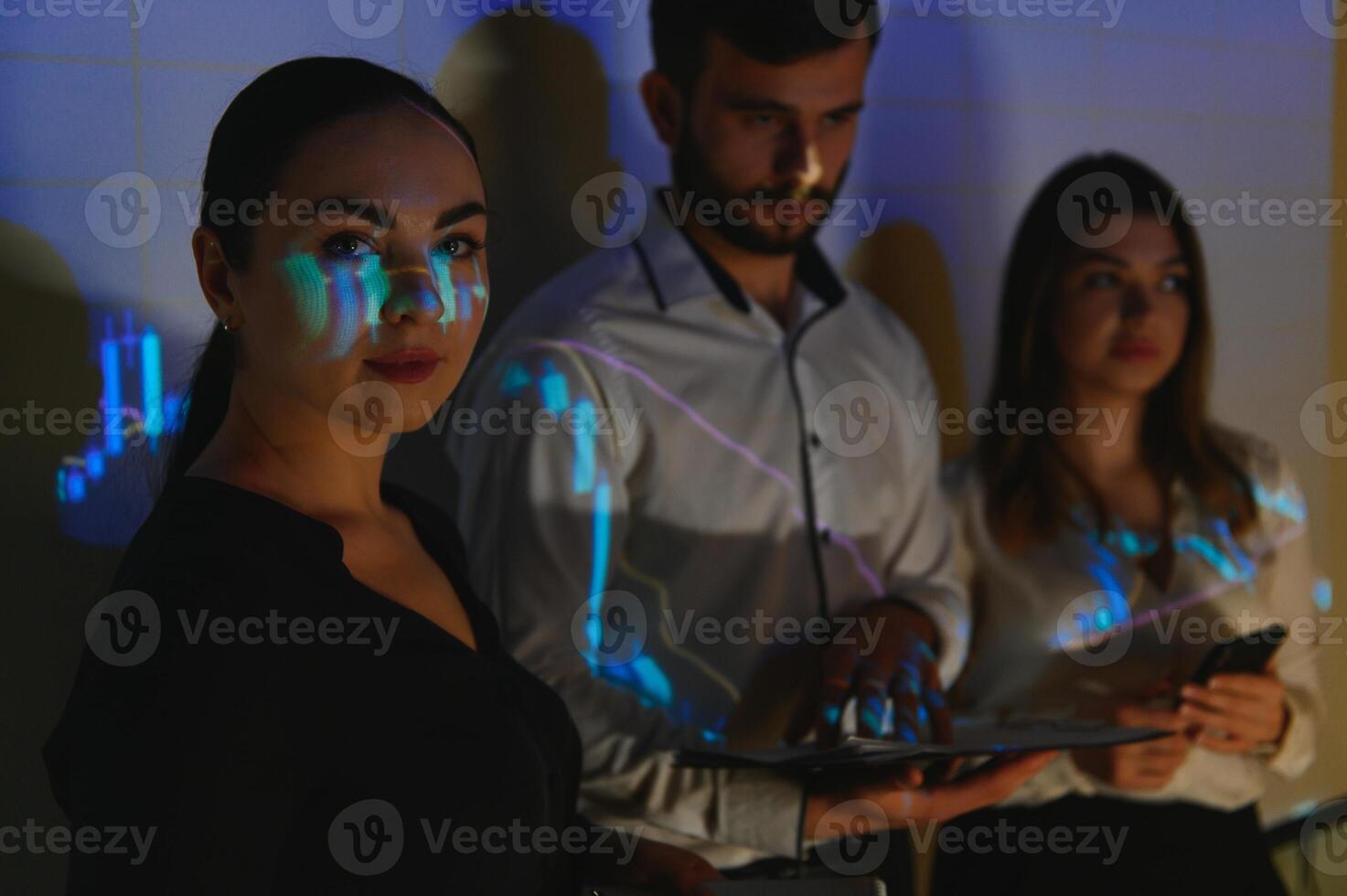 Trading teaching. Male leader talking to employees, showing the plan on the projector in office of stock exchange company. photo
