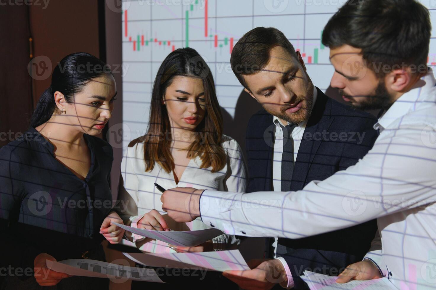 Group of business people working at modern office.Technical price graph, red and blue candlestick chart and stock trading computer screen background. Double exposure. Traders analyzing data photo